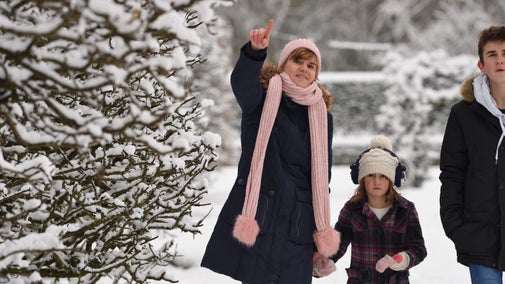 Mother with children pointing at snowy landscape